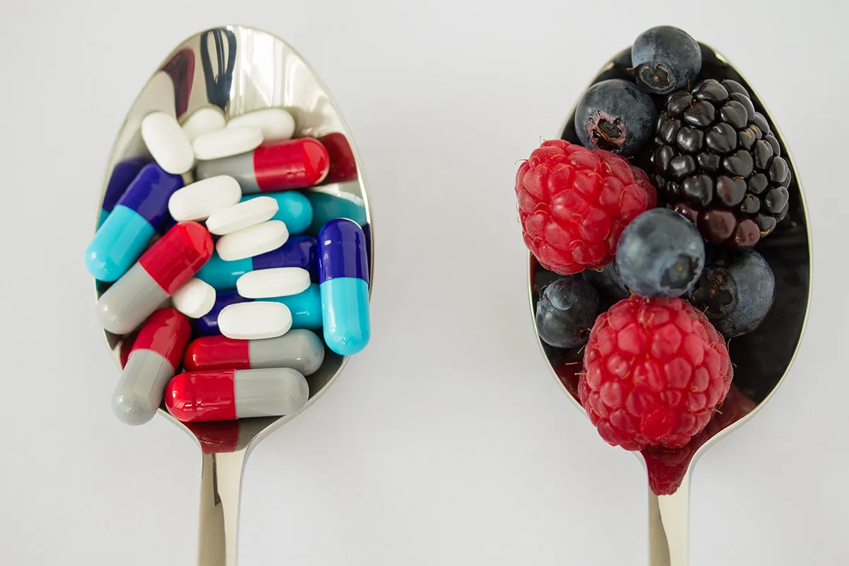 Medikamente und Beeren auf einen Löffel